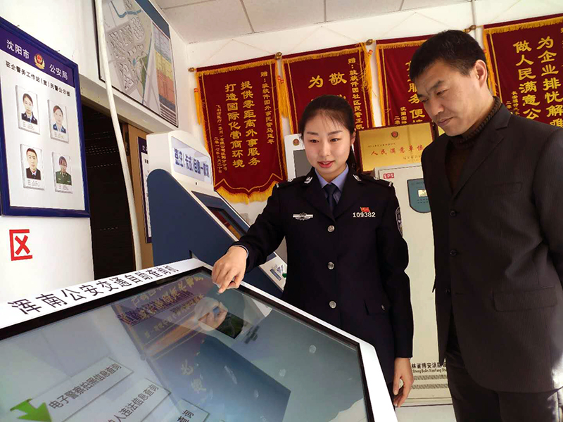 王凱迪（左）演示自助機(jī)操作方法