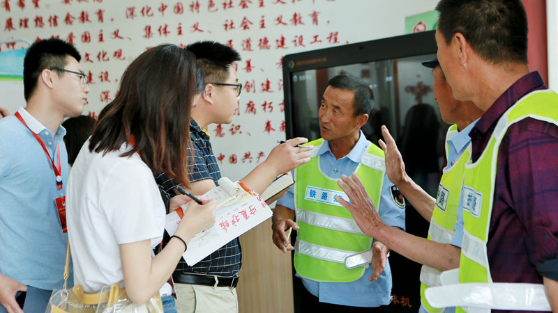 采訪團(tuán)成員同護(hù)路隊(duì)員交談