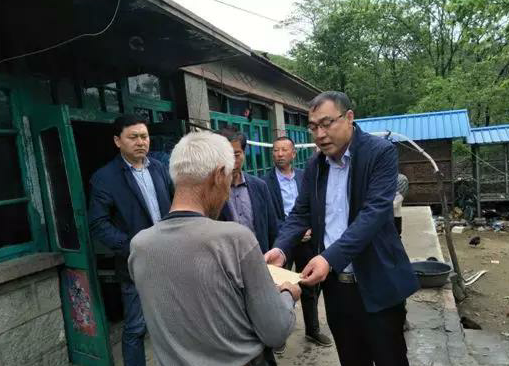 金龍(右一)探望貧困村民