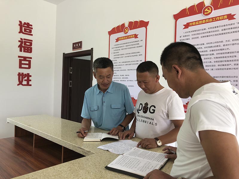 記者采訪當(dāng)天,王洪明(左一)正在和大安口村黨總支書記、村主任研究村里的新致富產(chǎn)業(yè)