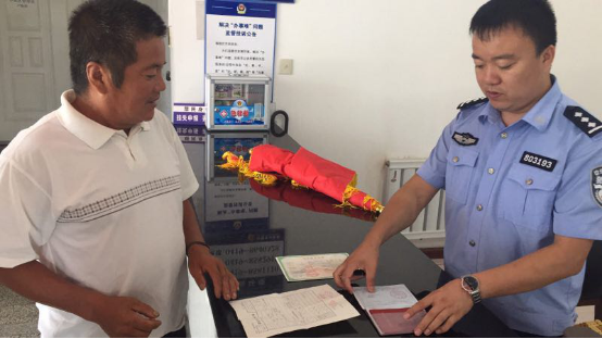 王賀（右）在為群眾辦理戶籍手續(xù)