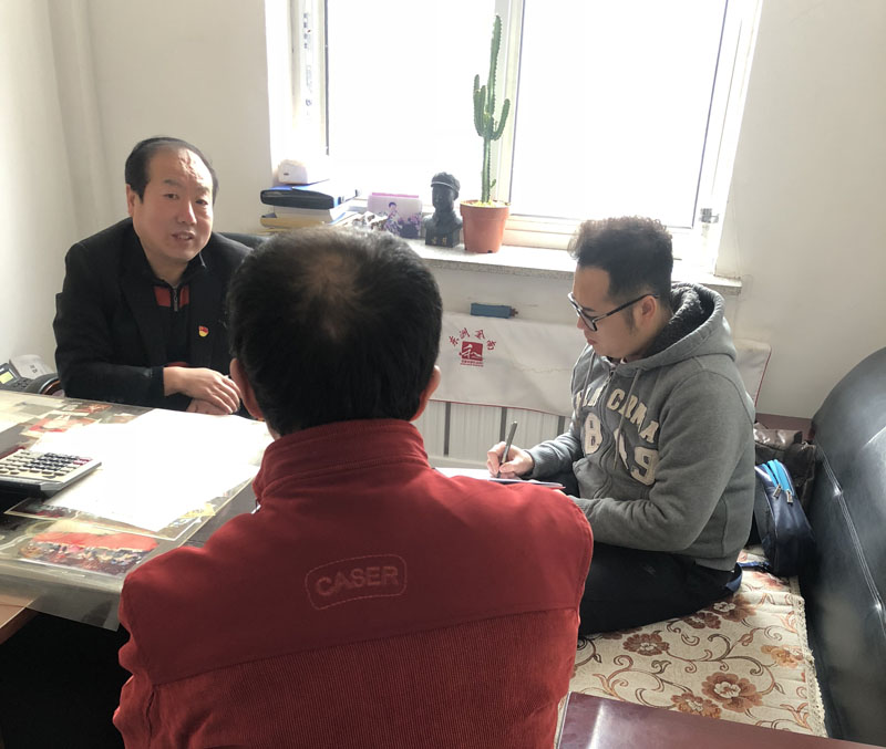 記者（右一）與馬慶國（左一）一起與社區(qū)居民聊天