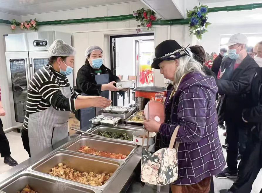 配文1：社區(qū)居民在食堂打飯。