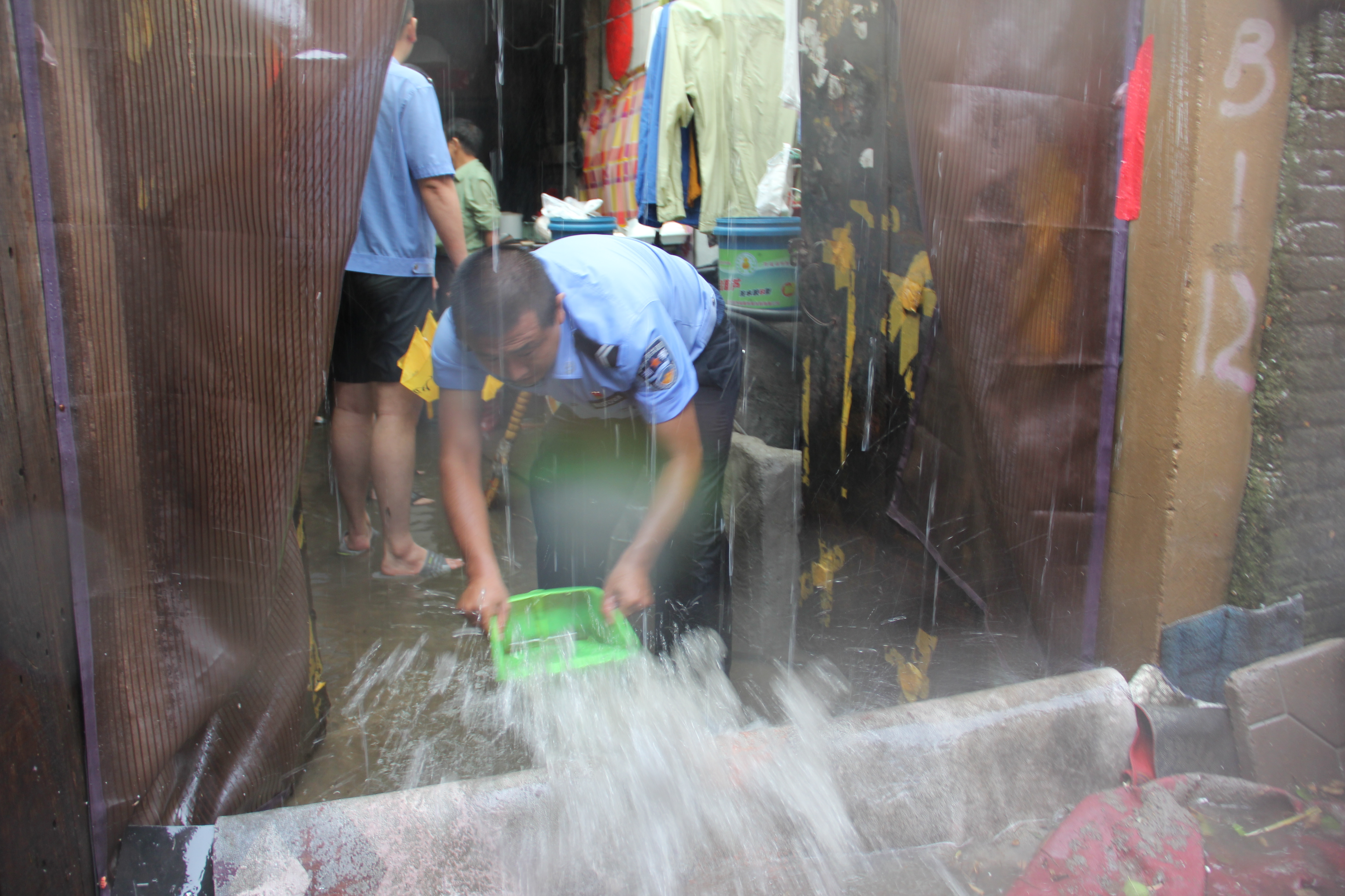 雨水倒灌居民家，葫蘆島市公安局連山分局渤海街派出所民警手動(dòng)排水。