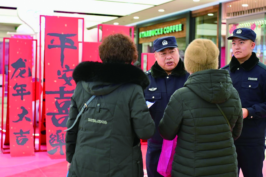 春節(jié)期間，民警老徐（左二）囑咐群眾要防范電信詐騙