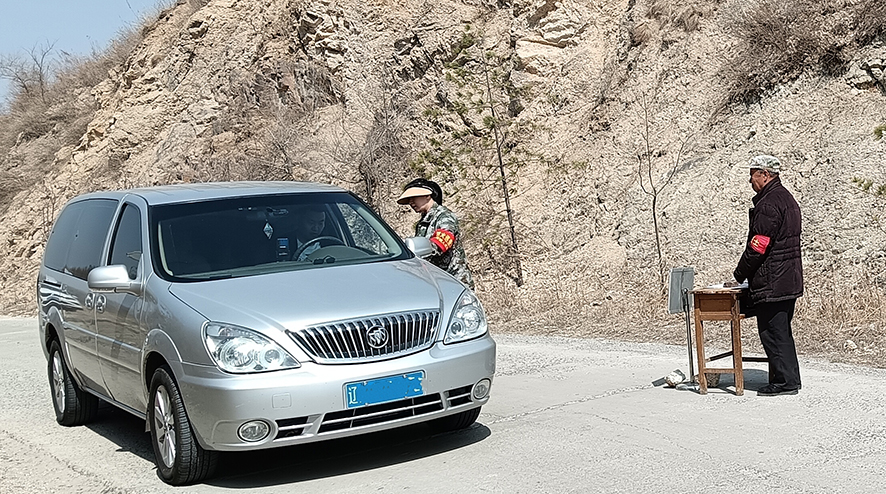 佟玲（右二）在對(duì)過(guò)往車輛檢查登記