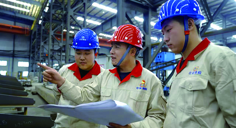沈陽中辰鋼結(jié)構(gòu)工程有限公司先鋒黨員、遼寧省勞動(dòng)模范劉權(quán)(中)在車間調(diào)度工作