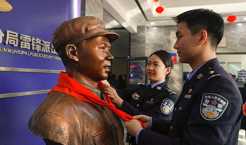 2024年3月5日,撫順市公安局望花分局雷鋒派出所民警白靜(右)和長(zhǎng)沙市公安局雷鋒派出所民警韓政霖(左)共同為雷鋒塑像整理紅領(lǐng)巾。
