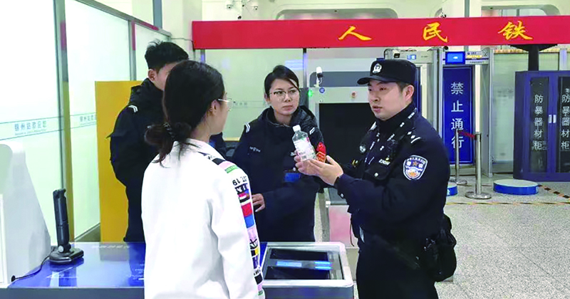 二題圖，童秋華（右）在向旅客講解安檢規(guī)定