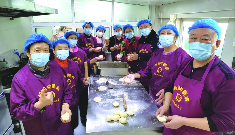 “媽媽廚房”志愿者們在后廚包包子場景