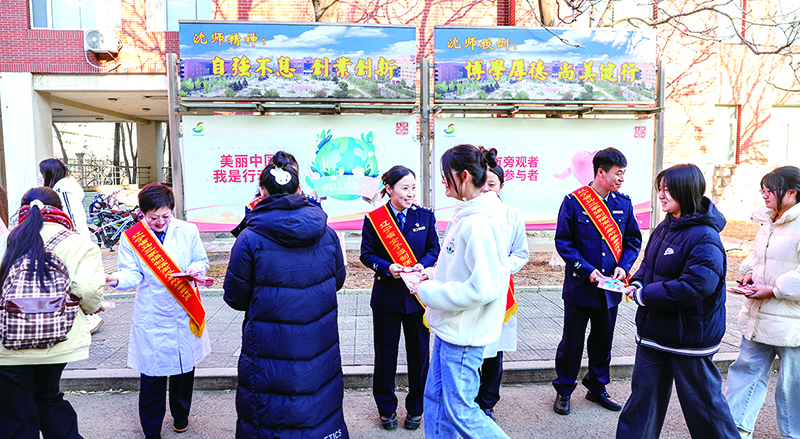 頭題圖，戒毒干警在沈陽師范大學(xué)校園發(fā)放宣傳單。