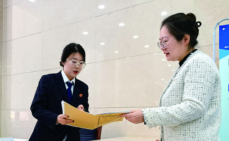 訴服中心的涉企案件綠色通道窗口，法官助理張嘉鑫正耐心指導(dǎo)當(dāng)事人填寫訴答文書