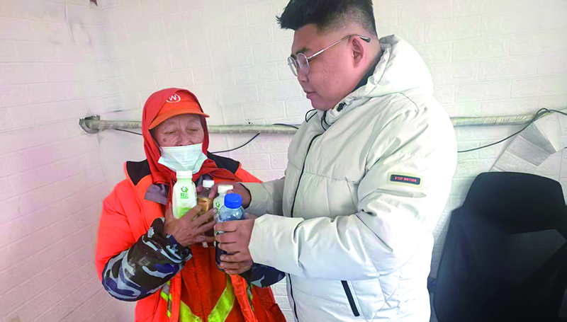 孫志強(右一)將廢品整理后交給環(huán)衛(wèi)工人