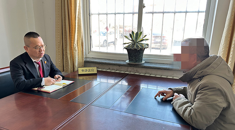 趙建峰(左一)在“法律診室”為前來咨詢的群眾解答法律問題。