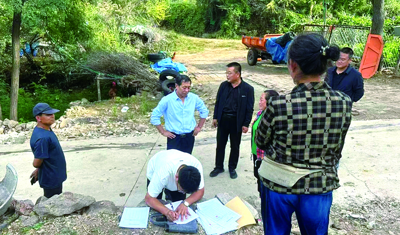 法官現(xiàn)場(chǎng)調(diào)解鄰里土地糾紛