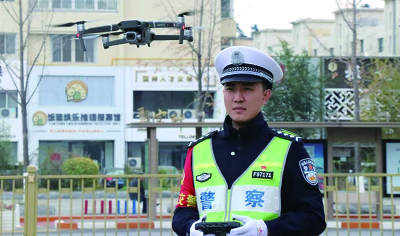 頭題圖,交警在執(zhí)勤工作中準(zhǔn)備使用“無人機(jī)”監(jiān)控車流量。