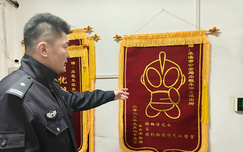 孟慶為向記者講述奧特曼錦旗的來(lái)歷